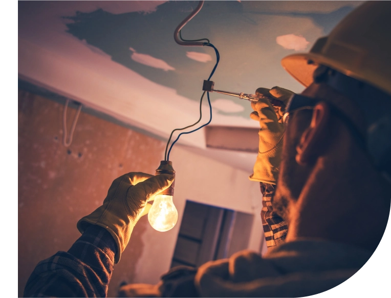 Electrician inspecting lighting system for safety compliance in commercial facility.